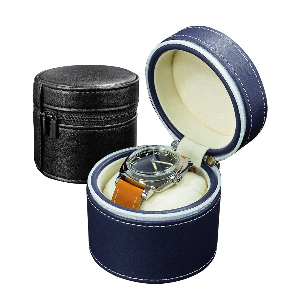 Watch box set shown on a white background, featuring a navy blue open cylindrical watch box with a silver watch inside, a black cylindrical watch box closed behind it.